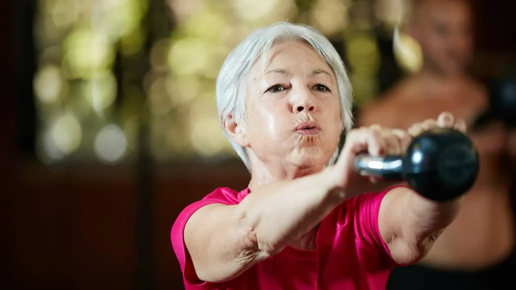 Toning Arms Without the Bulk: Is It Achievable? 1 Woman doing resistance band exercises for toned arms Woking