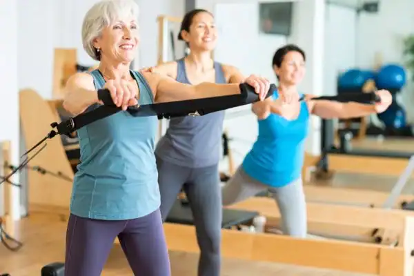 Toning Arms After 60: Empowering Womens Fitness Through Effective Weight Training 2 older woman doing weight training Woking and resistance in the gym to tone upper arms